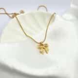 “Gold anti-tarnish bow pendant necklace on white satin background”